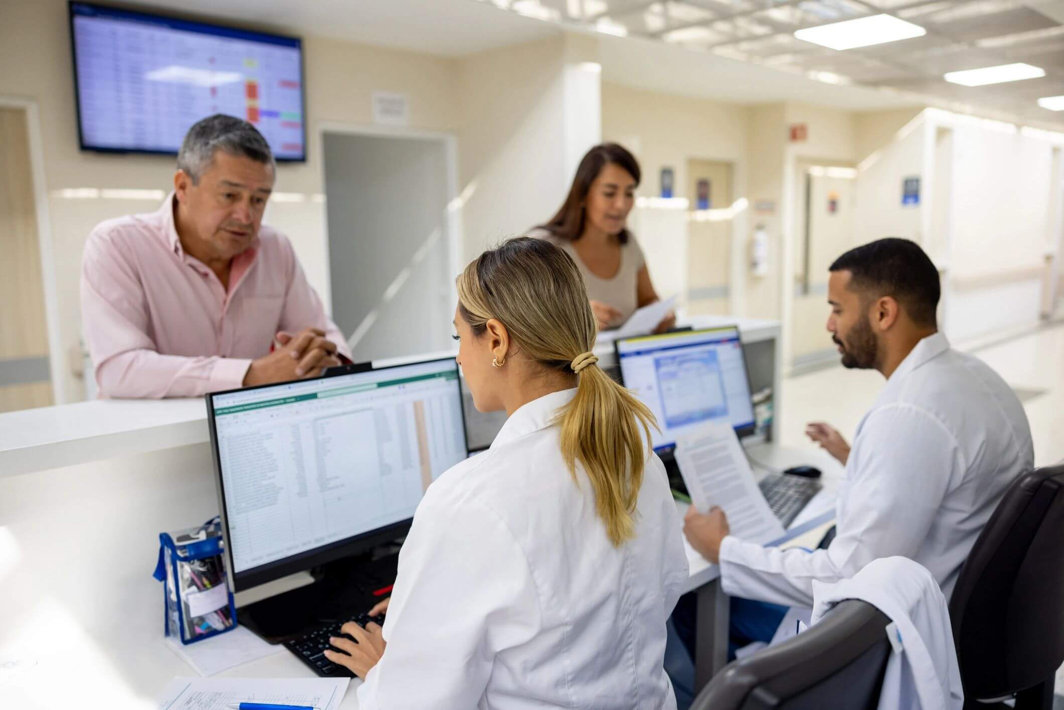 Medical professionals analyzing data on computers in a hospital.