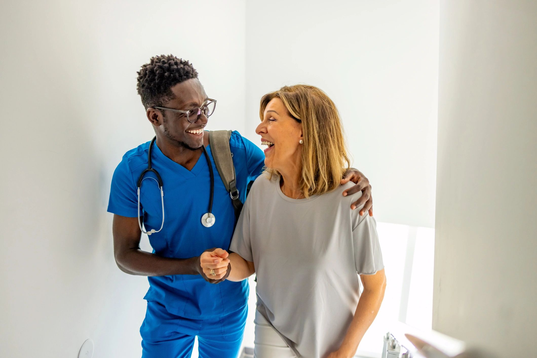 A nurse encouraging a smiling patient during a consultation.