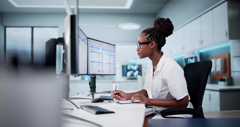 Scientist analyzing data on computer screens.