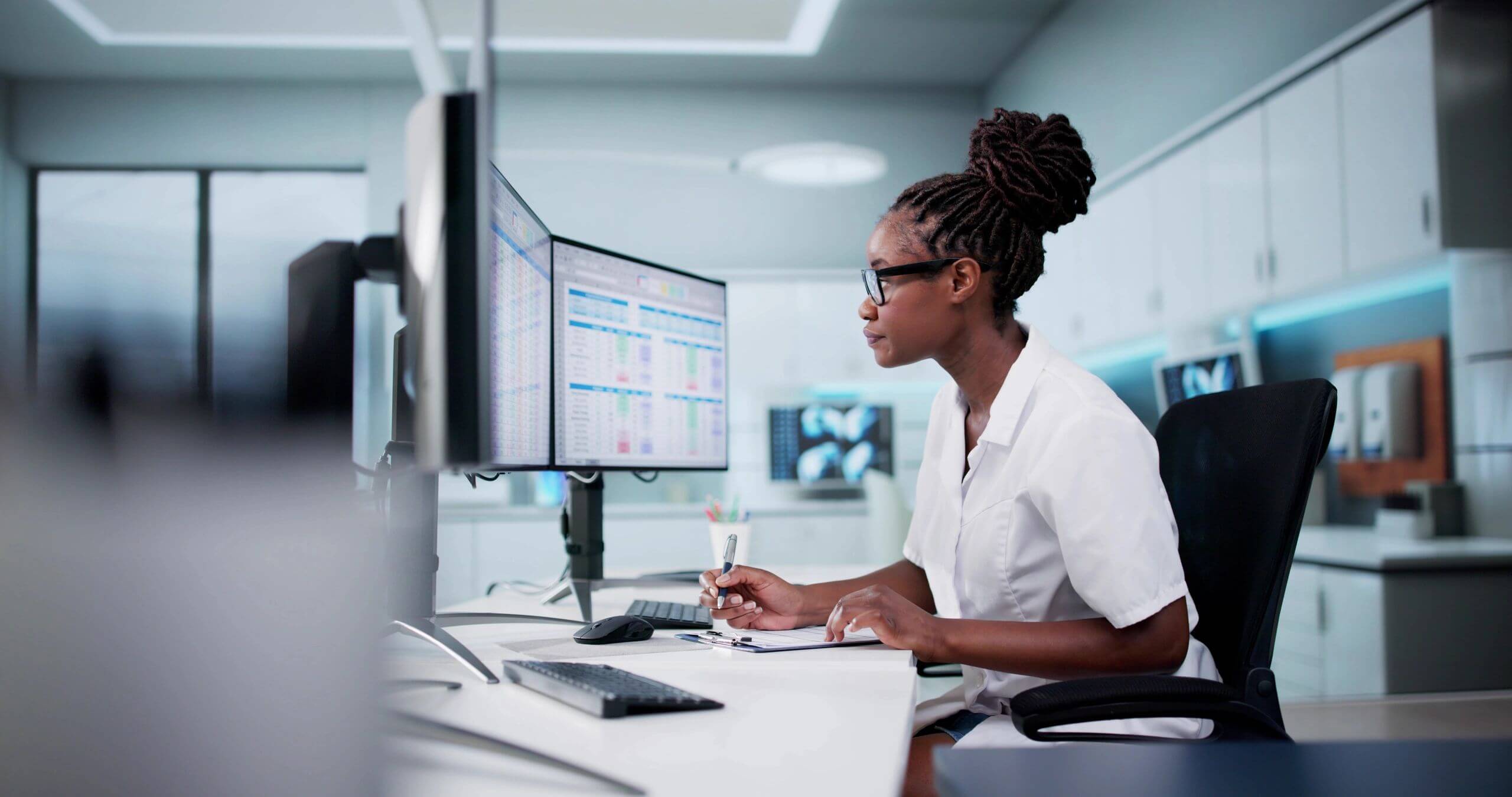 Scientist analyzing data on computer screens.